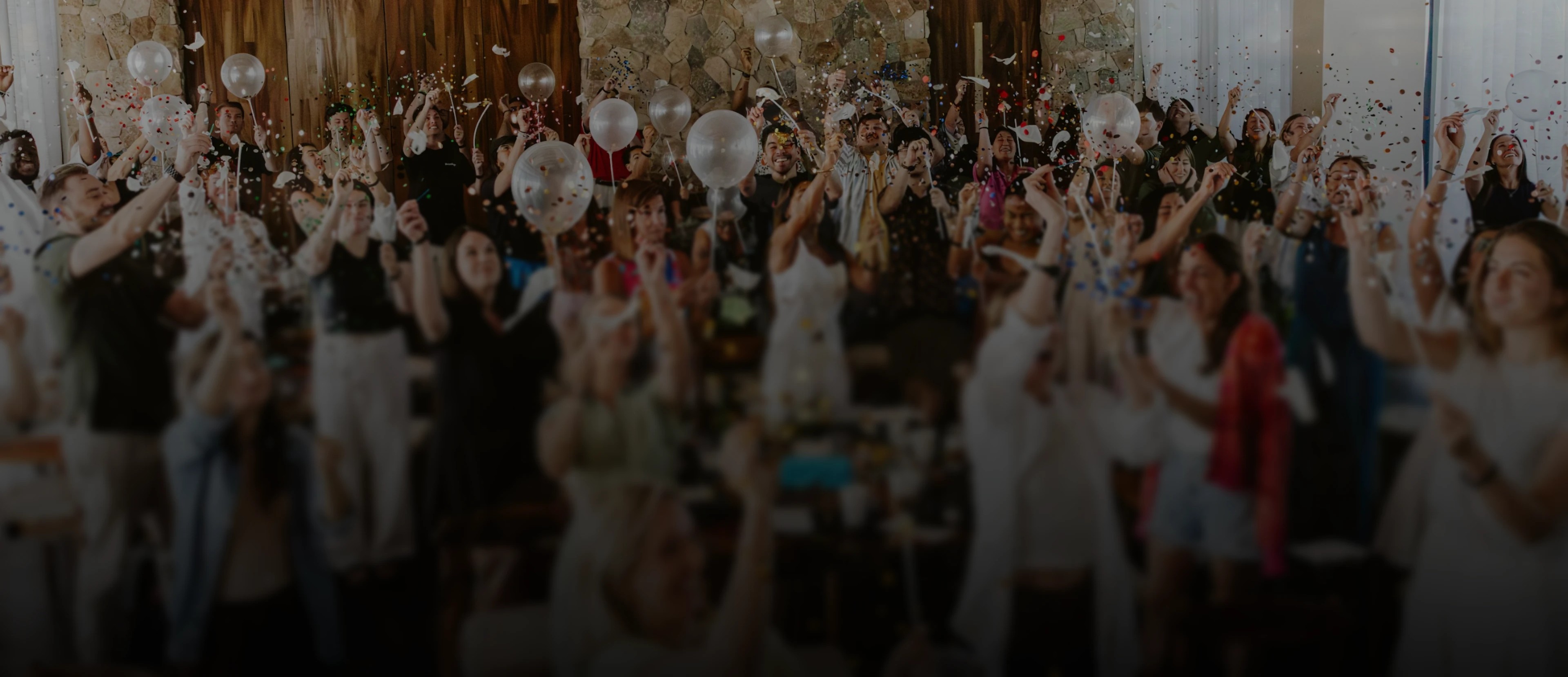 A large group celebrating with confetti and balloons at an event planned on the BoomPop platform